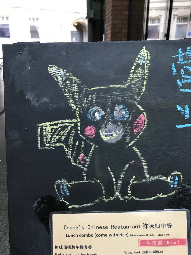 A chalk drawing of Pokemon character Pikachu on a restaurant menu board.