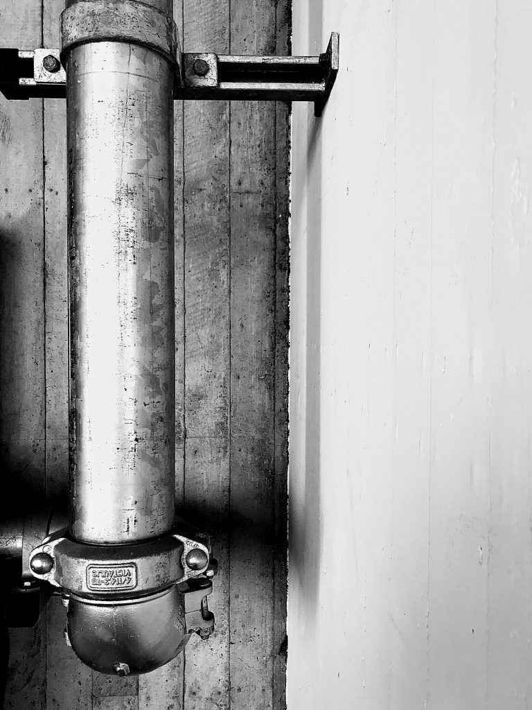 A black and white photograph of a metal pipe