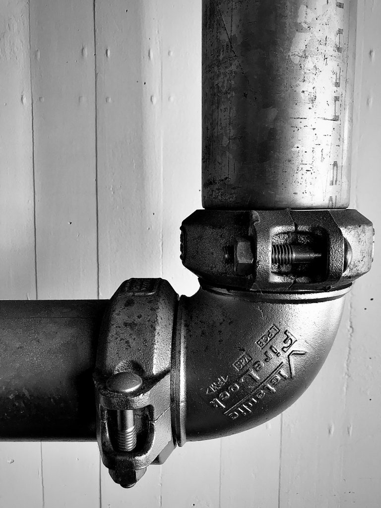 A close up black and white photograph of a metal pipe