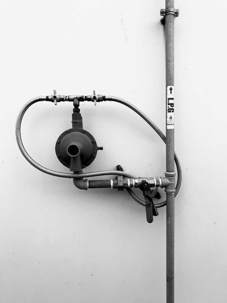 A black and white photograph of a water system on a white wall