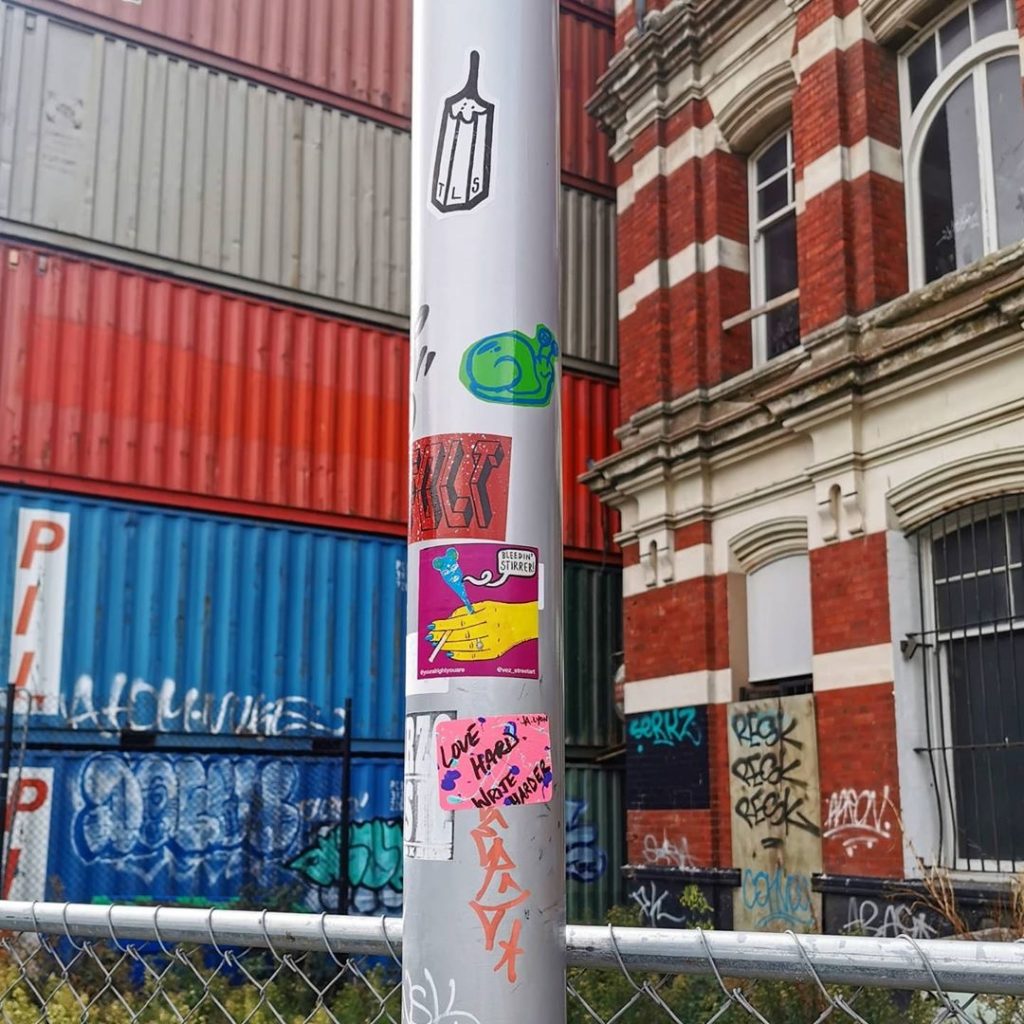 A collection of stickers on a lamppost in Christchurch