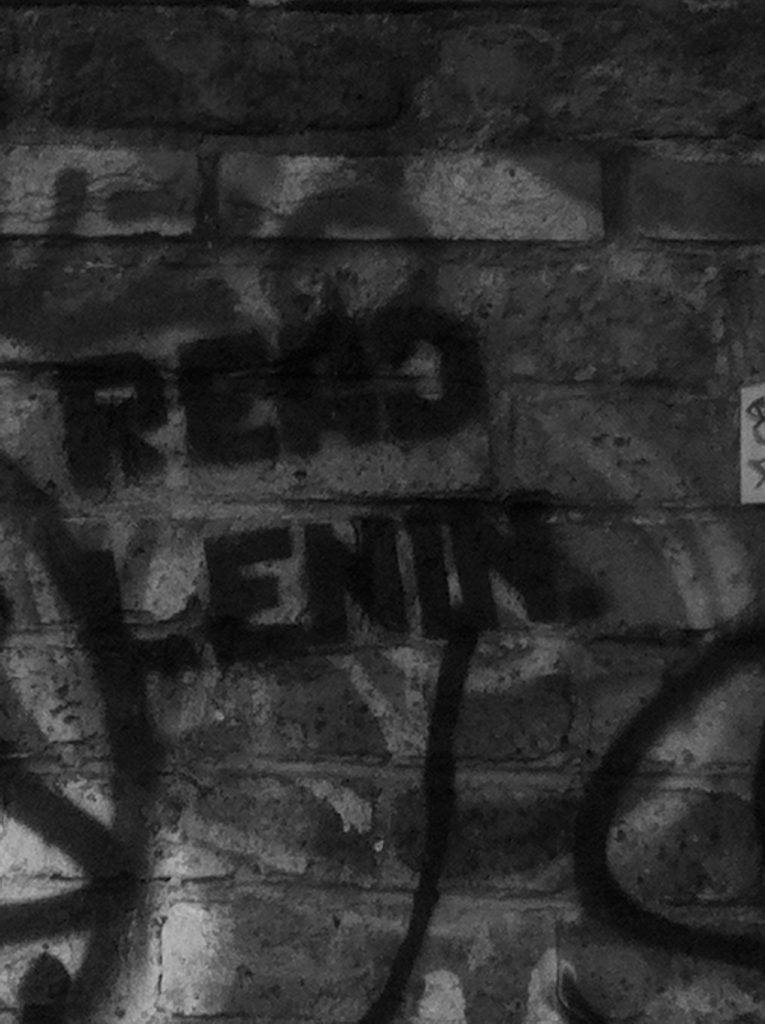 The words Read Lenin stencilled on a graffitied wall