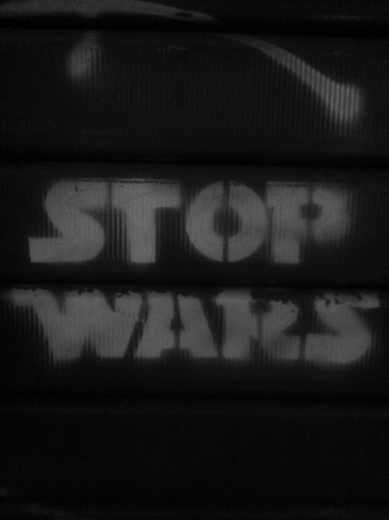 The words Stop Wars is stencilled in the style of the Star Wars logo