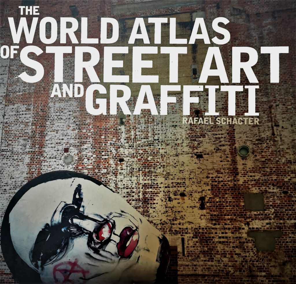 The cover of the book The World Atlas of Street Art and Graffiti, featuring a painting by Anthony Lister on a brick wall