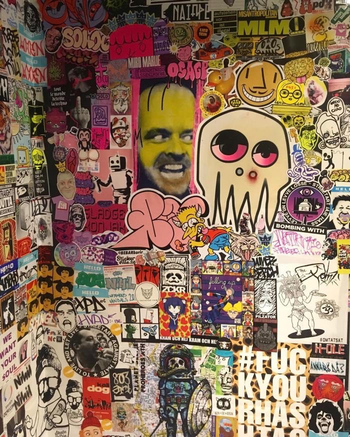 A wall covered in stickers at a sticker fest.