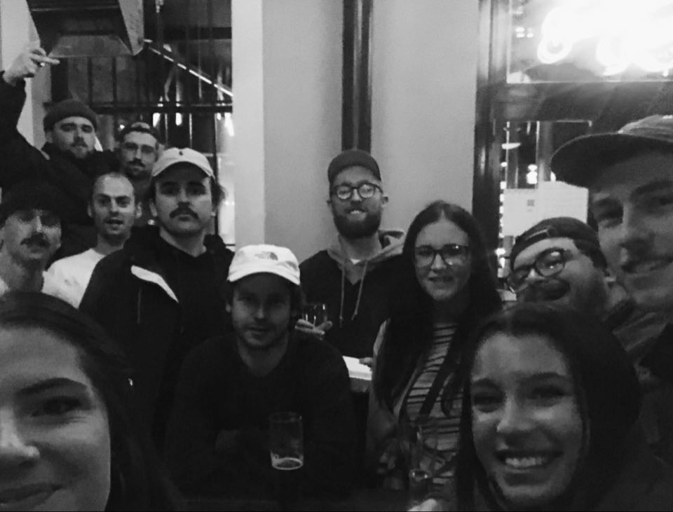 A crowd of friend gather outside a bar as people can return to small public gatherings. 