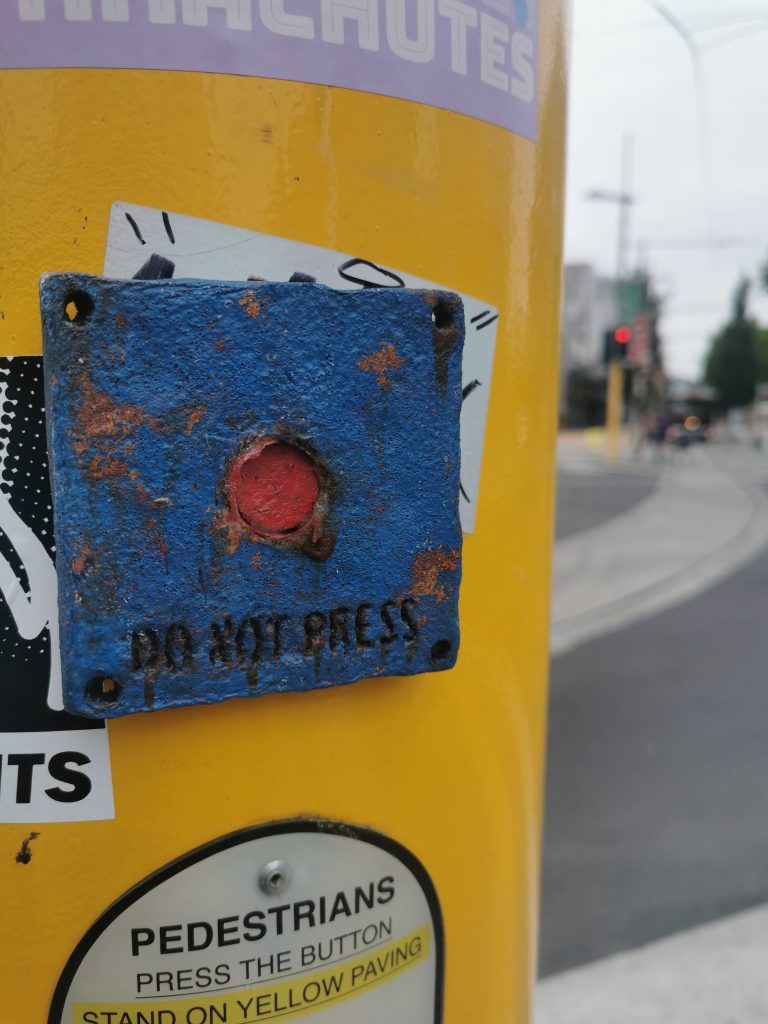 One of Mike Beer's 'Do Not Press' buttons applied to central Christchurch streets. When passersby could not follow the advice, and pressed the button, sriracha sauce oozed out...