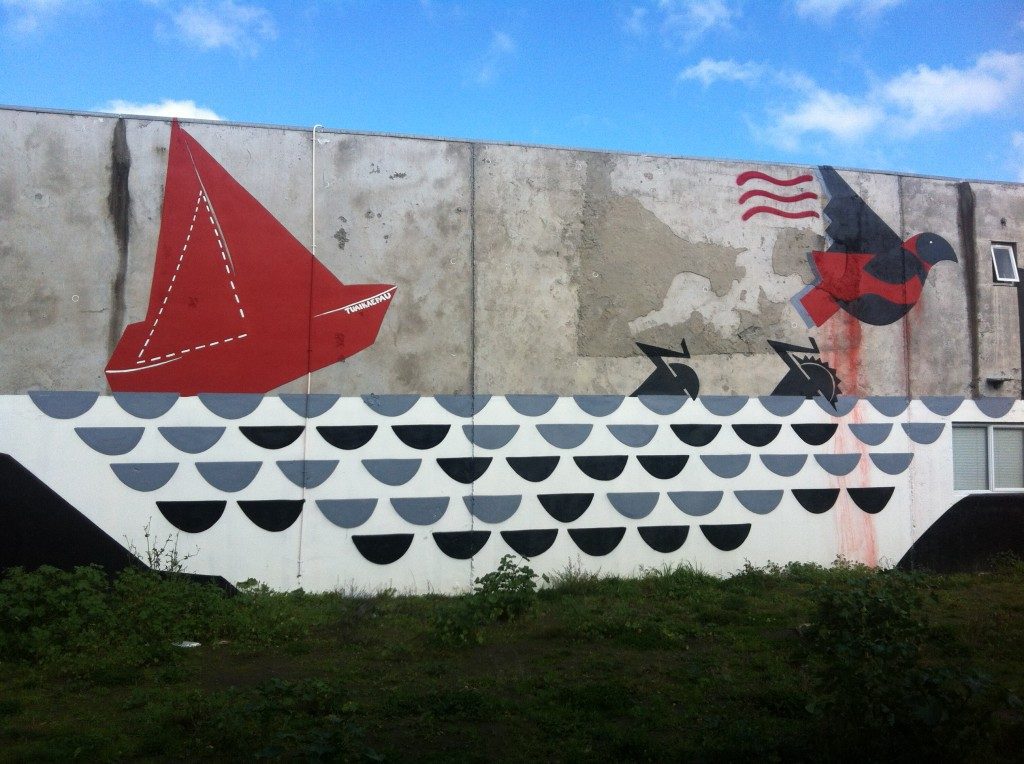 Work's mural for From the Ground Up in 2013. The image in red, black, grey and white, features figures escaping from a ship wreck with a bird flying above them.